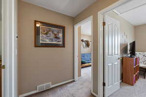 Corridor with carpet flooring and baseboards