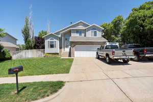 View of front facade with concrete driveway, a garage, and brick siding