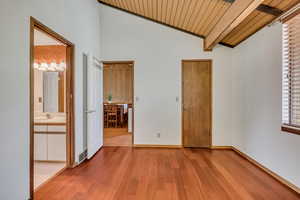 Unfurnished bedroom featuring wood finished floors, wooden ceiling, baseboards, and a sink