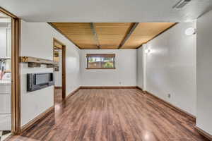 Spare room featuring wood finished floors, washer / clothes dryer, baseboards, and wooden ceiling