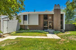 View of front of house with a chimney and brick siding