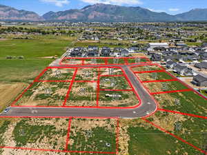Aerial view of residential area with property parcel outlined and a mountainous background
