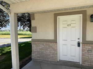 Entrance to property with stucco siding and brick siding