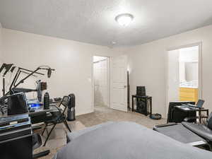 Carpeted bedroom featuring a textured ceiling and baseboards
