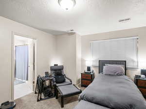Bedroom featuring a textured ceiling and carpet