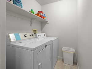 Washroom featuring washer and clothes dryer and baseboards
