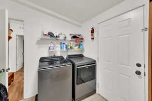 Washroom featuring washer and clothes dryer and light tile patterned flooring