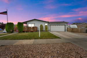 Ranch-style house with driveway, a garage, and a wooden deck