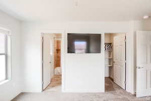 Unfurnished bedroom with light colored carpet