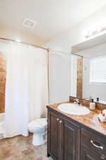 Full bathroom featuring vanity, toilet, and shower / bathtub combination with curtain