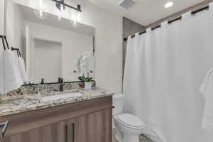 Full bath with vanity, toilet, and a shower with curtain