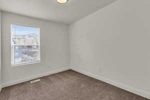 Carpeted empty room featuring baseboards