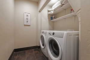 Laundry area with independent washer and dryer and baseboards