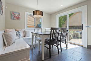 Dining space featuring recessed lighting, dark tile patterned floors, and a chandelier