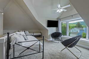 Carpeted bedroom featuring vaulted ceiling and baseboards