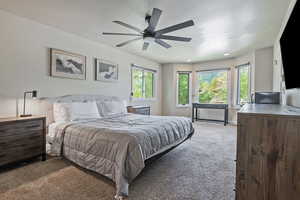 Bedroom with carpet floors, a textured ceiling, and ceiling fan