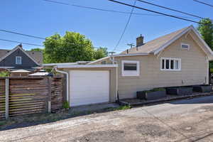 View of home's exterior with a chimney and roof with shingles