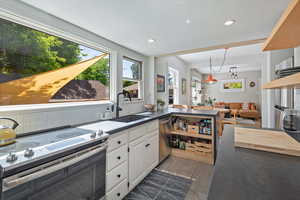 Kitchen featuring stainless steel appliances, a sink, white cabinets, recessed lighting, and a peninsula