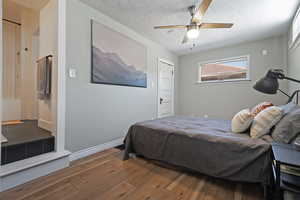 Bedroom featuring wood-type flooring, a textured ceiling, a ceiling fan, and baseboards