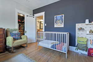 Bedroom with hardwood / wood-style floors and baseboards