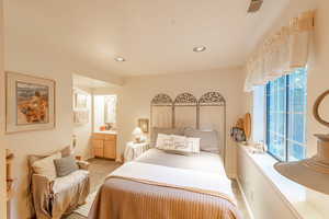 Bedroom featuring light carpet, baseboards, and recessed lighting.  The bedroom includes a small vanity with a sink.  Perfect guest bedroom.