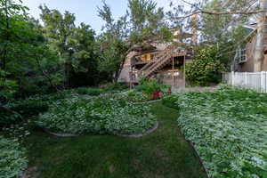 View of deck, stairs, and landscaped yard.