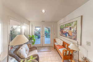 Sitting room with french doors, light tile patterned flooring, and recessed lighting