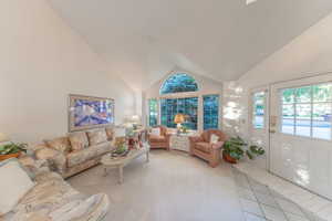 Living area featuring a high vaulted ceiling, and plenty of natural light.