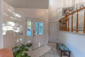 Open entrance foyer with stairs, and vaulted ceiling