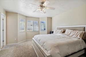 Carpeted bedroom with baseboards and a ceiling fan