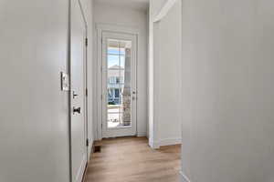 Doorway to outside with baseboards and light wood-style flooring