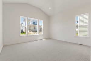 Carpeted spare room with vaulted ceiling, baseboards, and recessed lighting