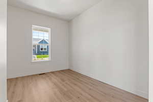 Spare room featuring light wood-type flooring and baseboards