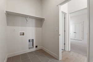 Laundry area with hookup for a washing machine, baseboards, and tile patterned floors
