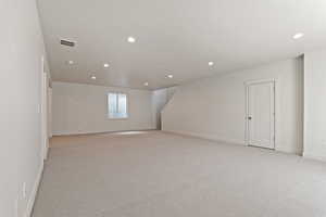 Below grade area with light carpet, baseboards, and recessed lighting