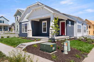 Craftsman-style home featuring covered porch and stucco siding