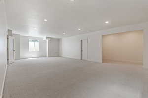 Basement with baseboards, light carpet, and recessed lighting