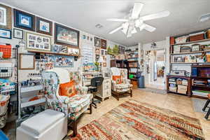 Sitting room with a desk and ceiling fan