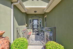 Entrance to property featuring stucco siding and a gate