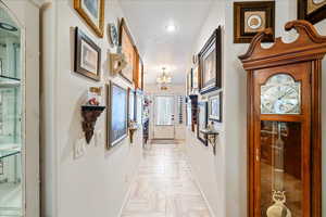 Hallway featuring a chandelier and recessed lighting
