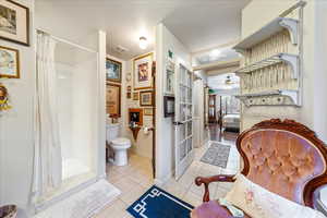 Bathroom with tile patterned flooring, a shower with curtain, ceiling fan, and french doors