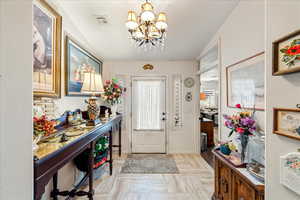 Entryway featuring a chandelier and baseboards