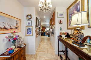 Corridor featuring a chandelier and recessed lighting