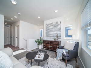 Living area with laminate wood floors and recessed lighting