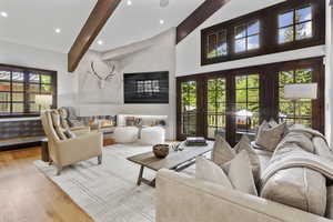 Living room featuring beamed ceiling, wood finished floors, recessed lighting, and high vaulted ceiling