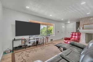 Living area with wood finished floors, recessed lighting, and a premium fireplace