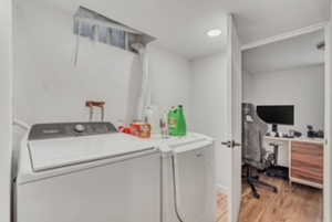 Laundry area featuring washing machine and dryer and light wood-type flooring