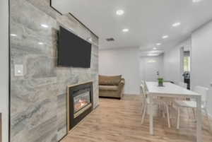 Dining space featuring recessed lighting, wood finished floors, and a fireplace