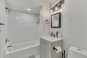 Full bath with toilet, vanity, and washtub / shower combination