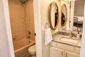 Full bathroom featuring vanity, bathtub / shower combination, and toilet